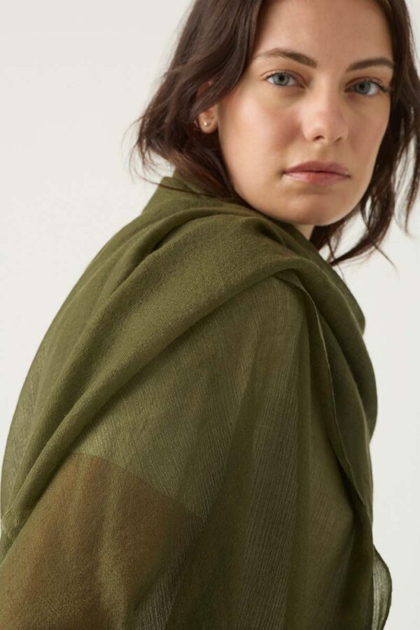 Woman wears featherweight cashmere scarf in olive