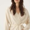 Woman wears 100% cashmere robe in ivory