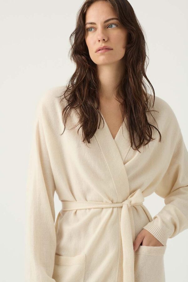 Woman wears 100% cashmere robe in ivory