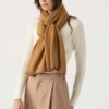 woman wears cashmere travel wrap in spice