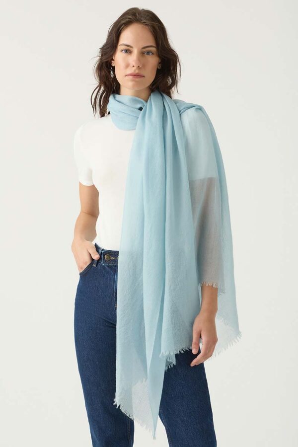Woman wears Featherweight Cashmere scarf in Sky Blue