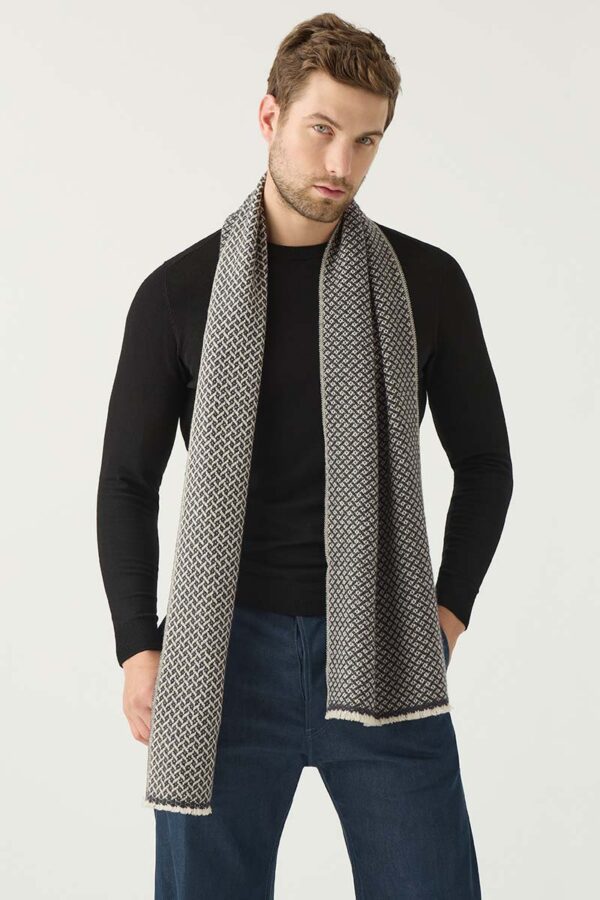 Man wears soft woven cashmere scarf in navy and light taupe