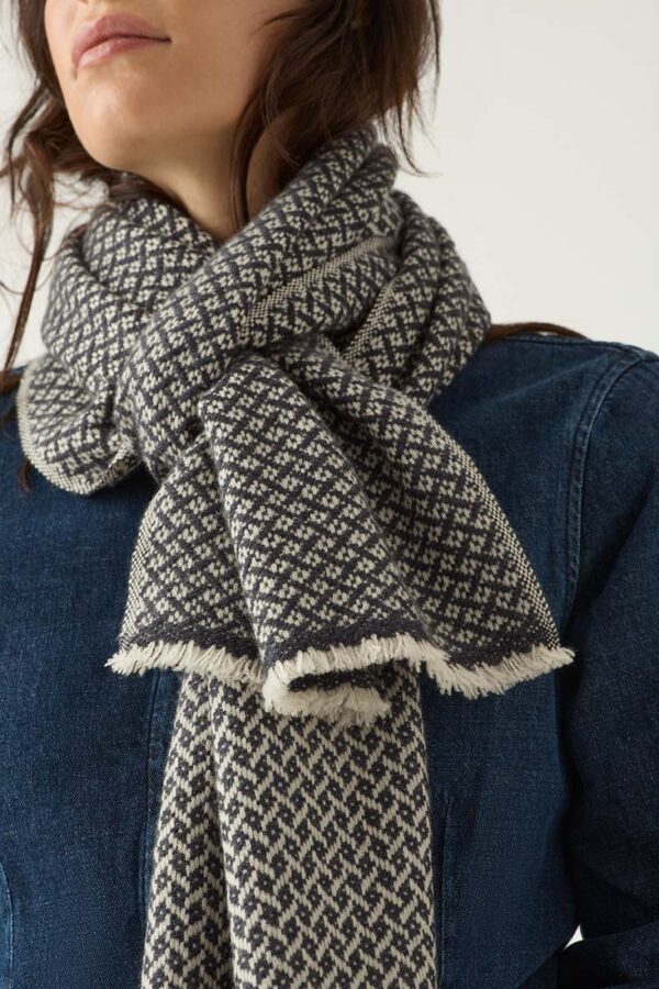 Woman wears cashmere scarf in navy and light taupe