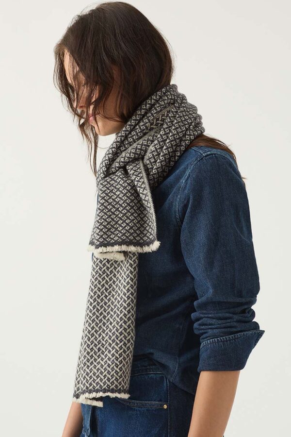 Woman wears a Kasmiri Cashmere handcrafted woven scarf in a striking pattern of navy and light taupe