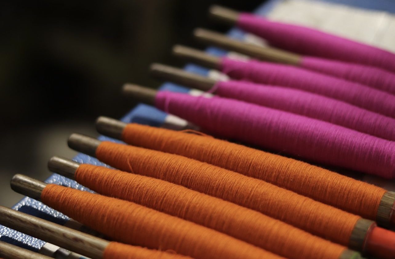 Rows of cashmere thread in Indian Rose and Tangerine at the Kasmiri Mill in Nepal