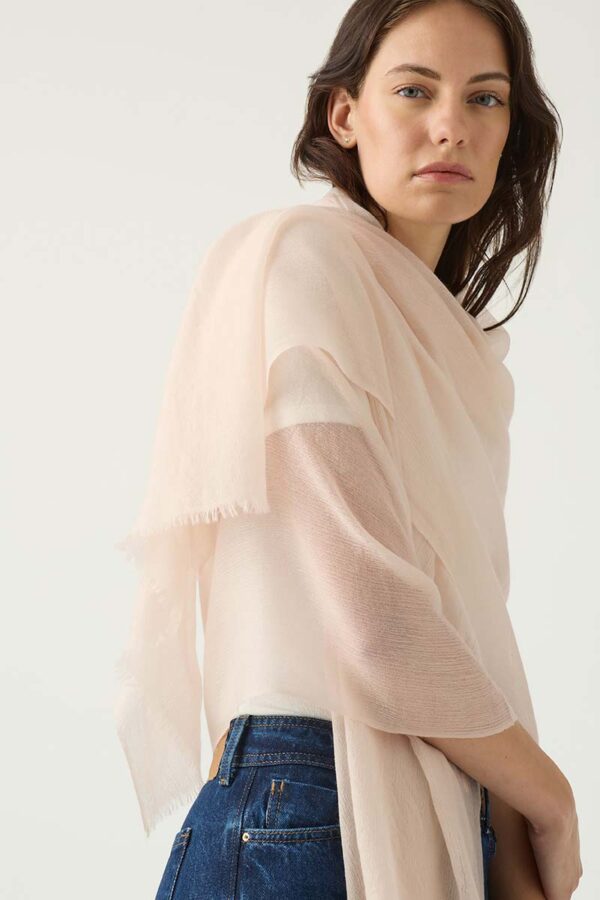 Woman wears cashmere scarf in blush
